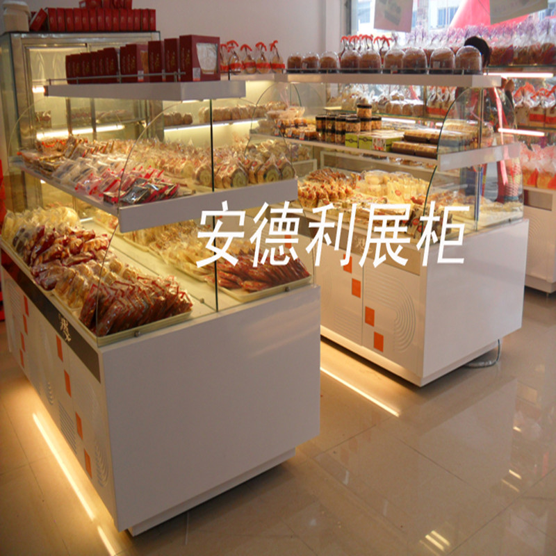 安德利面包柜产品特点: 1.中岛柜、边岛柜、收银台,盘柜,外形美观大方、精致新颖、结构坚固实用; 2.主要材质有:优质木质装饰板,优质不锈钢,钢化玻璃,高透明进口有机玻璃,防火板(外面可以火烧,但不变形),喷涂板,外面吸塑板; 3.台面可按客户要求做人造大理石,可以打客户的LOGO;台面下是储物箱,储物箱可以做抽屉式或拉门式; 4.